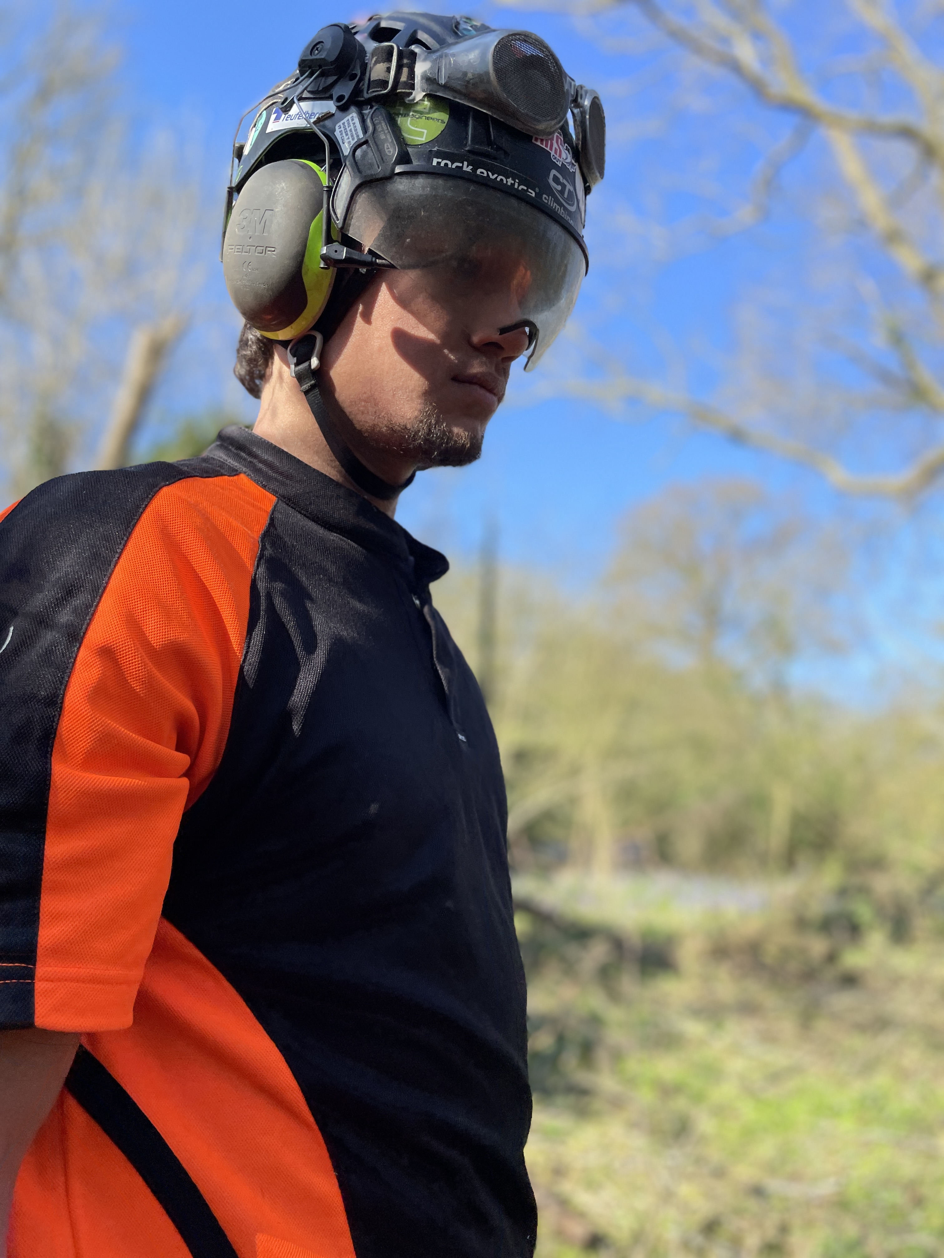 Person wearing safety gear outdoors on a sunny day.