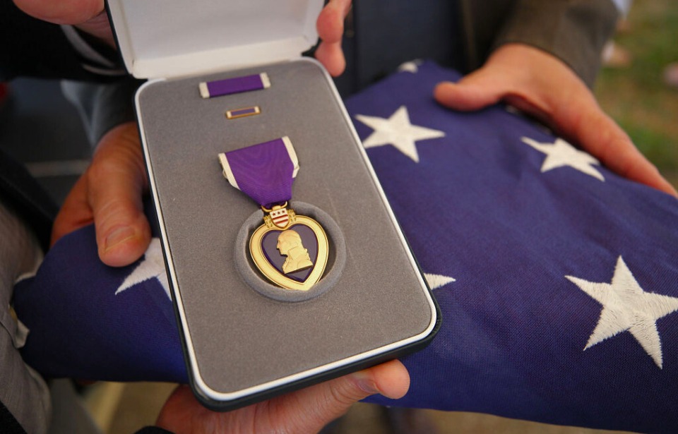 Purple Heart medal displayed alongside an American flag.