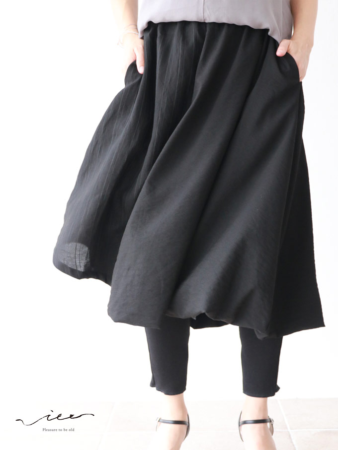 Person wearing a black skirt over black leggings, highlighting the outfit's flow.