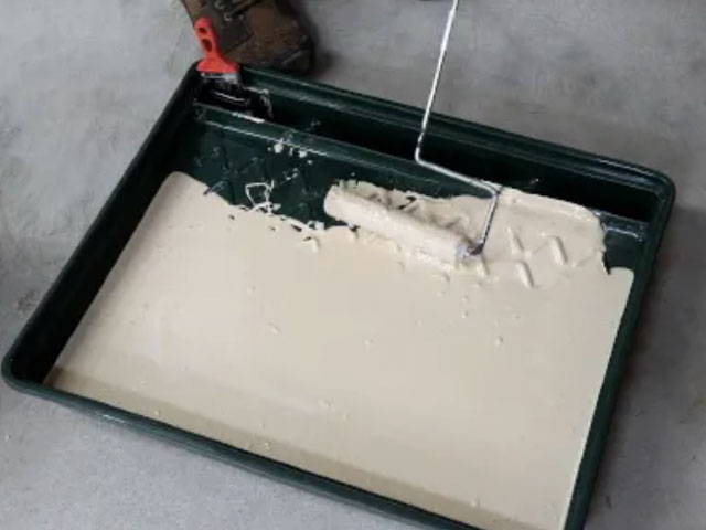 Applying Moisture Seal Epoxy Primer to the concrete block perimeter of the garage using a microfiber roller and paint brush.