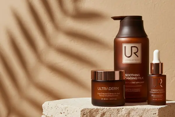 Three Urban Retreat skincare products on a stone surface with a shadow backdrop.