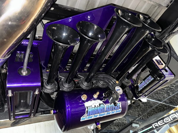 HornBlasters train horn kit with five black trumpets, metallic purple air tank, and matching purple brackets mounted under vehicle