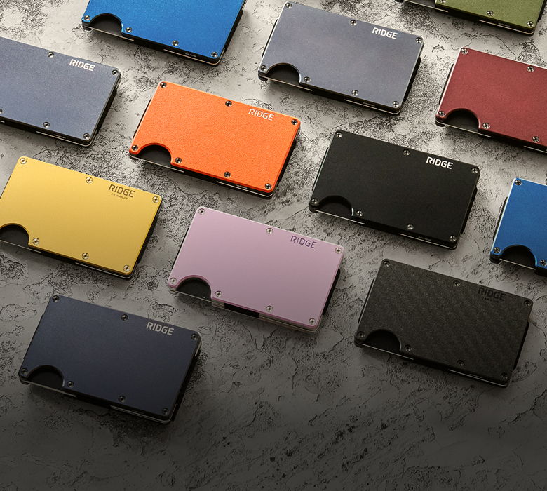 Various colored wallets arranged on a textured surface.