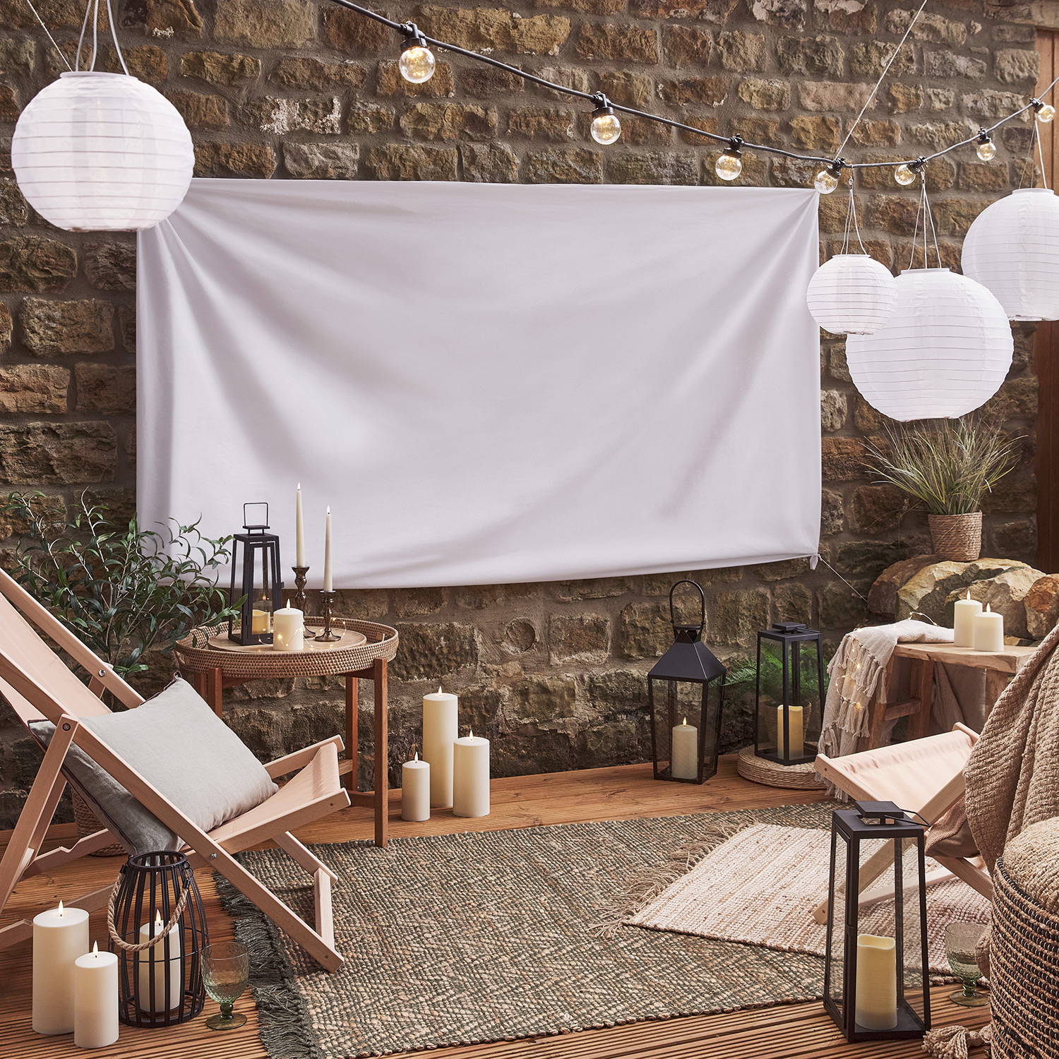 An outdoor movie setting during the day with outdoor hanging lanterns and festoon lights.