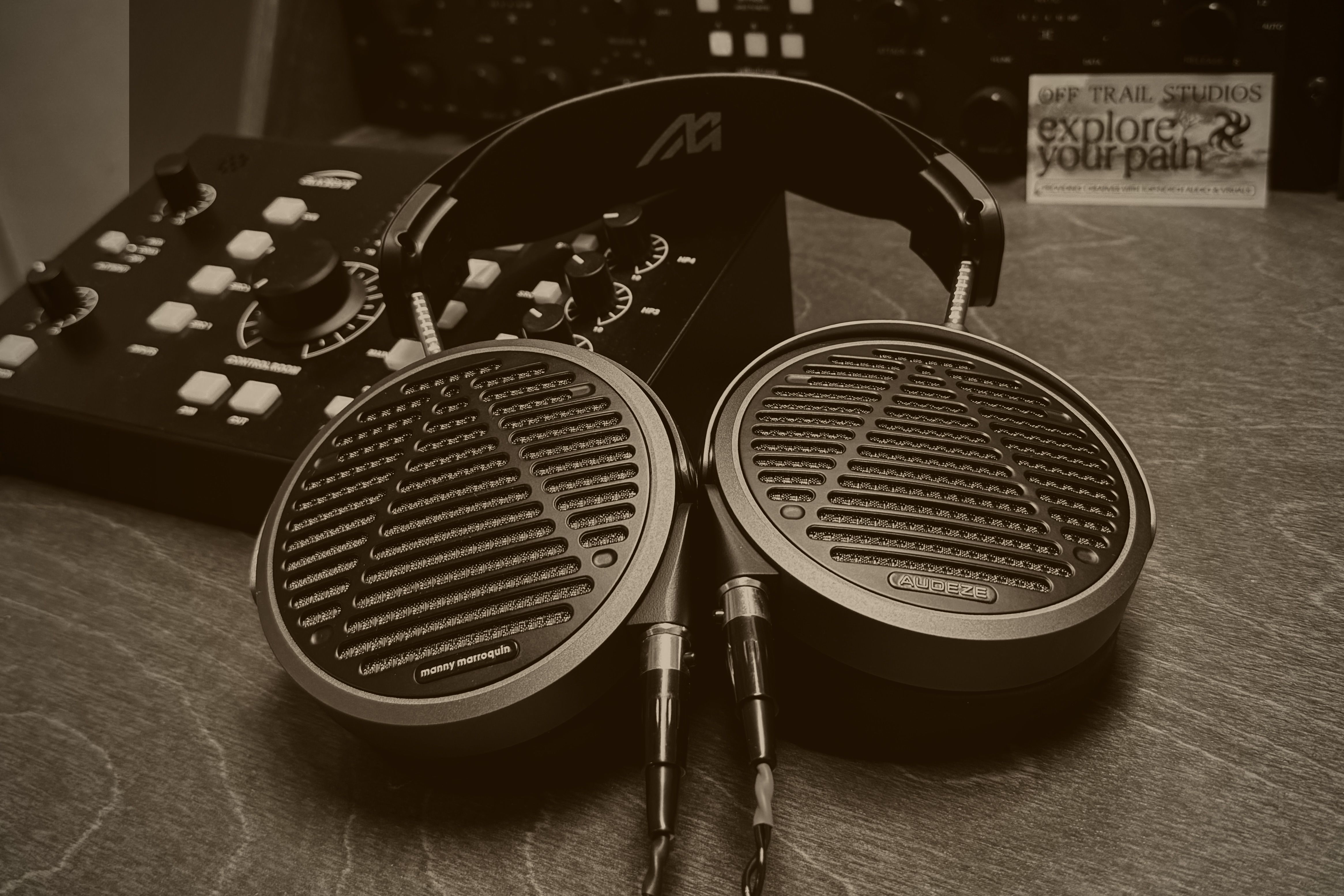 Audeze MM-500 headphones on a wooden surface next to audio equipment.