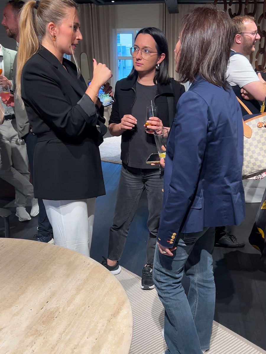 Three women engaged in conversation at a social gathering.