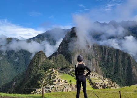Young woman wearing black and looking over Machu Picchu