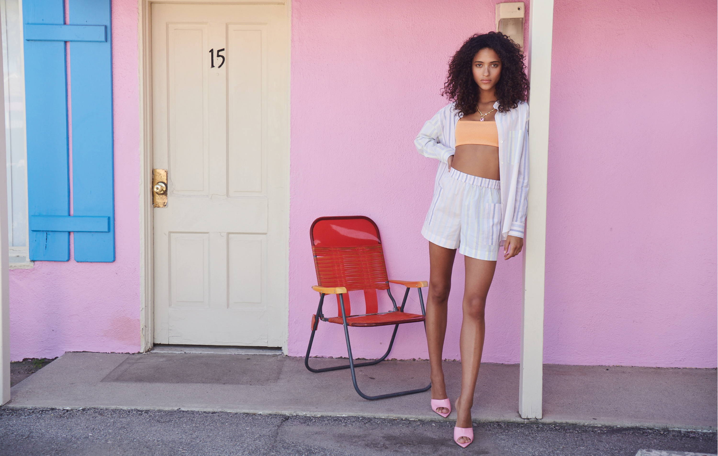 Model in front of hotel wearing Citrus Mixed Stripe shorts and shirt