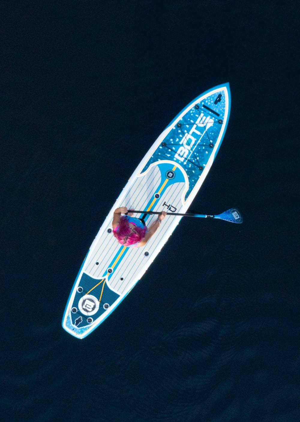 Overhead view of a woman paddling her HD Native Whale Shark Paddle Board