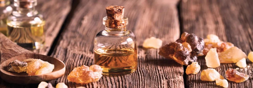 Bottles of oil and resin on a wooden surface.