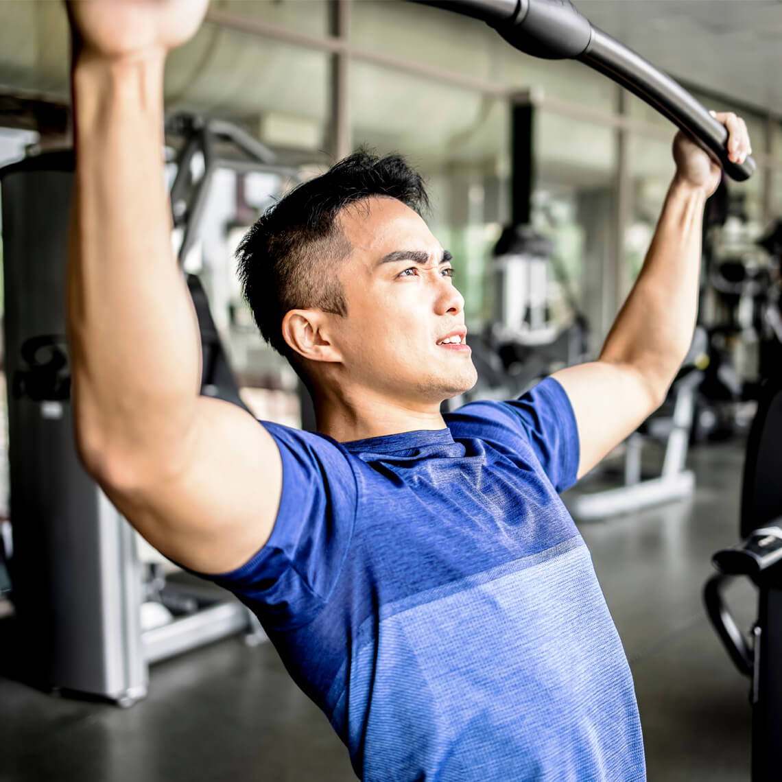 Man exercising with a barbell in a gym setting.