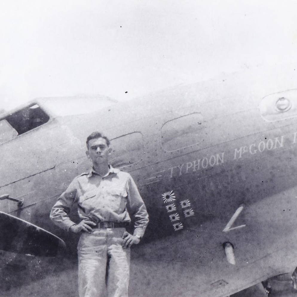 uniformed man standing in front of WWII Air Corps plane