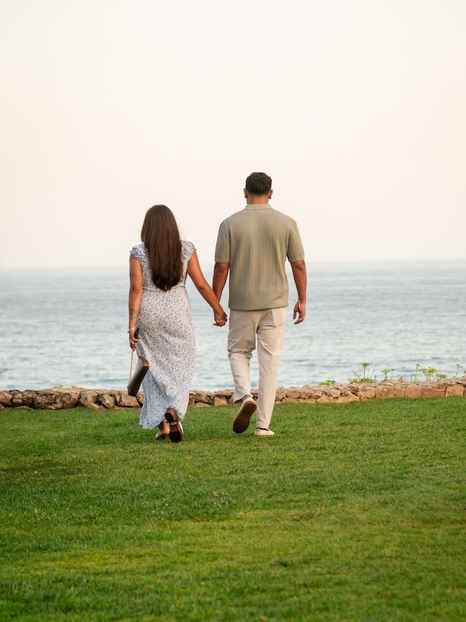 engaged couple holding hands cliffside, algarve, portugal