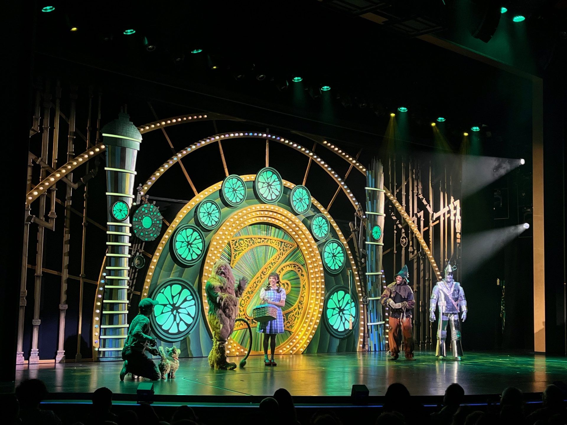 A theatrical performance with actors on stage and colorful lighting.