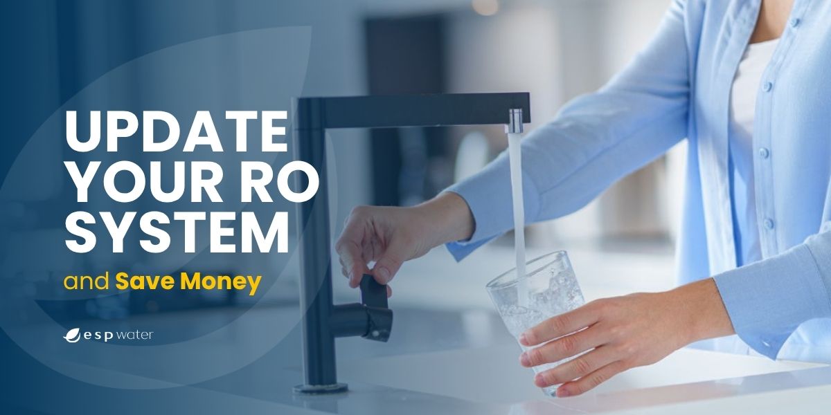 A person filling a glass with water from a modern kitchen faucet.