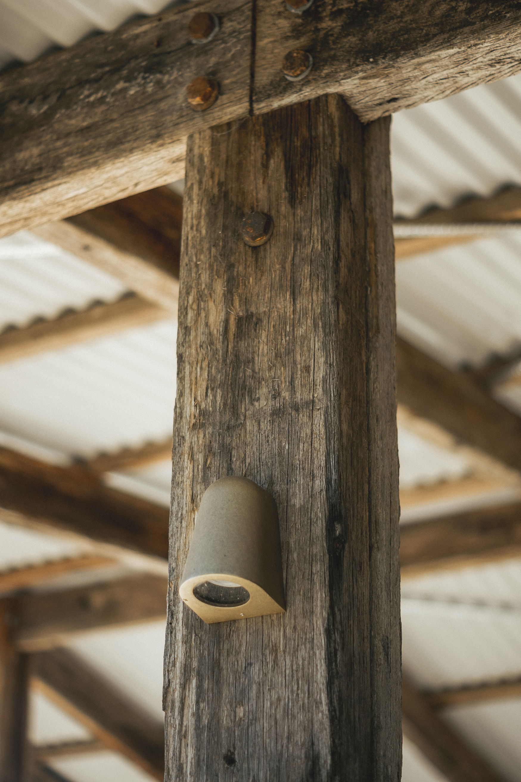 A wooden pillar with a light fixture attached.