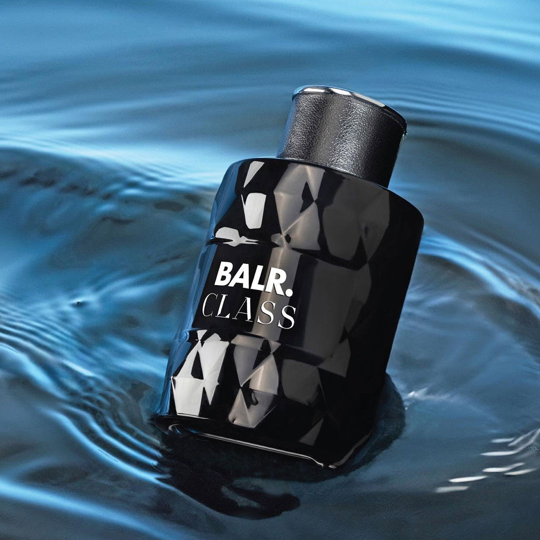 A black perfume bottle floating on water.