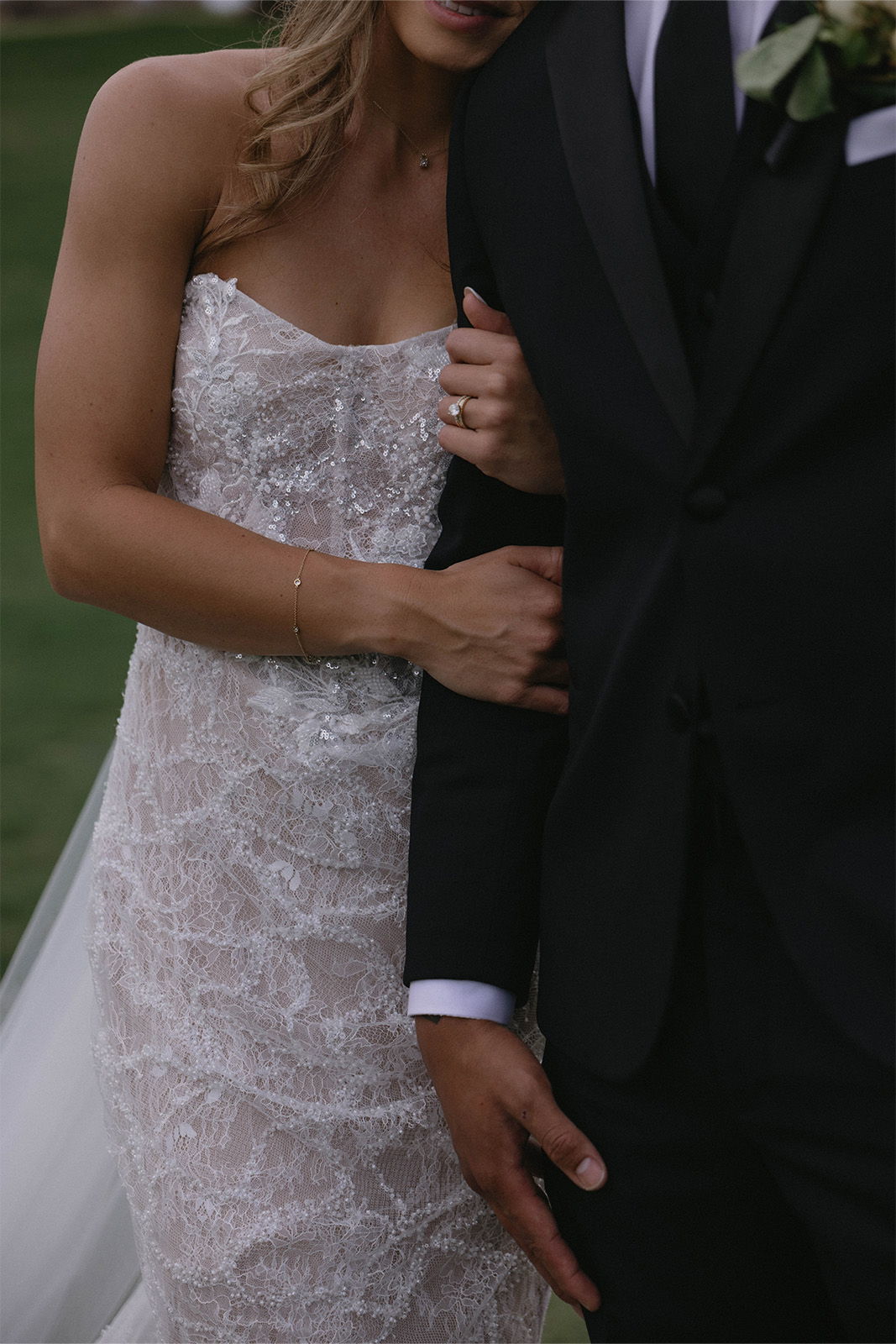 Bride and groom embracing, showcasing wedding attire and intimate moment.