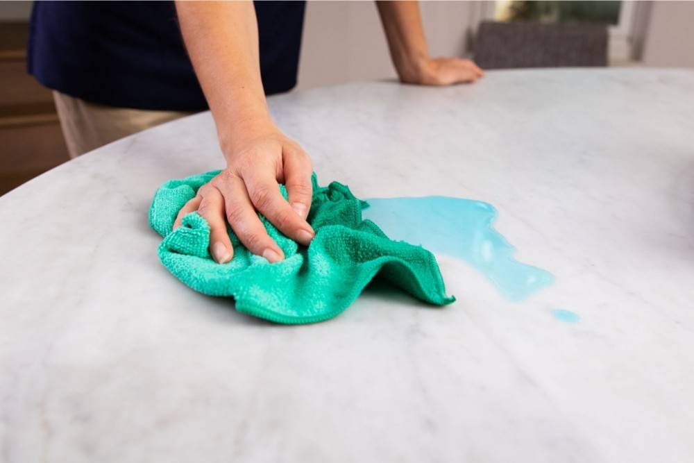 person cleaning mess with microfiber towel
