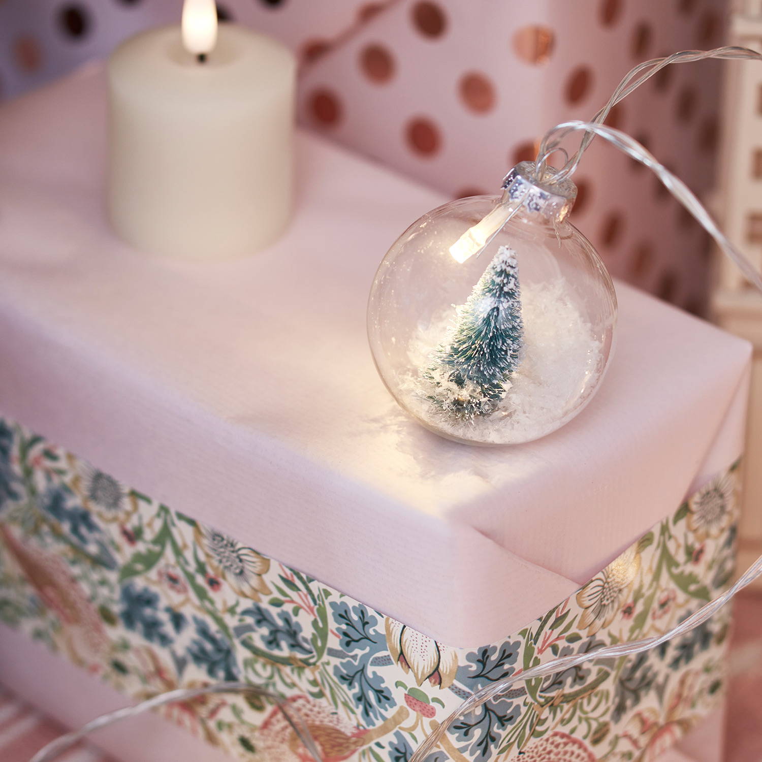 Snowy Christmas tree globe fairy lights on a pink Christmas present