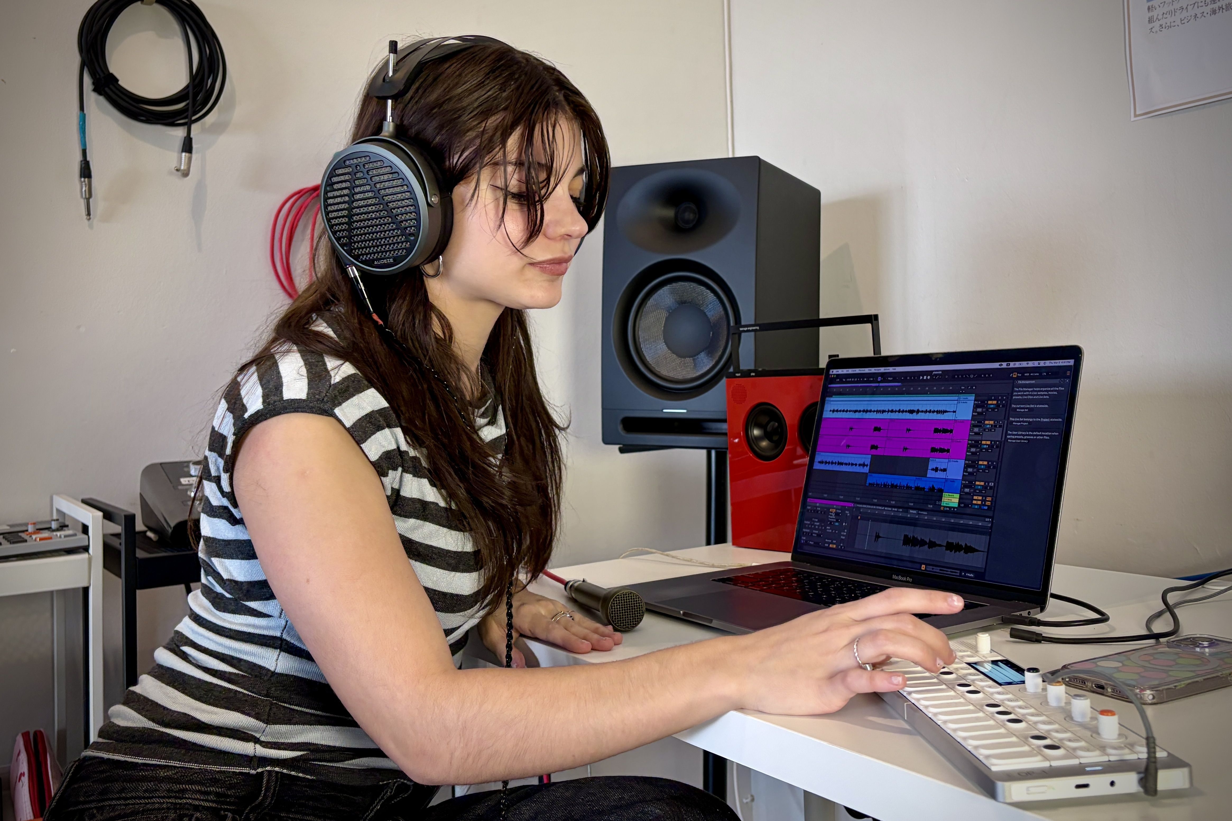 Martina Nintzel wearing Audeze MM-500 headphones working on music production at a laptop.