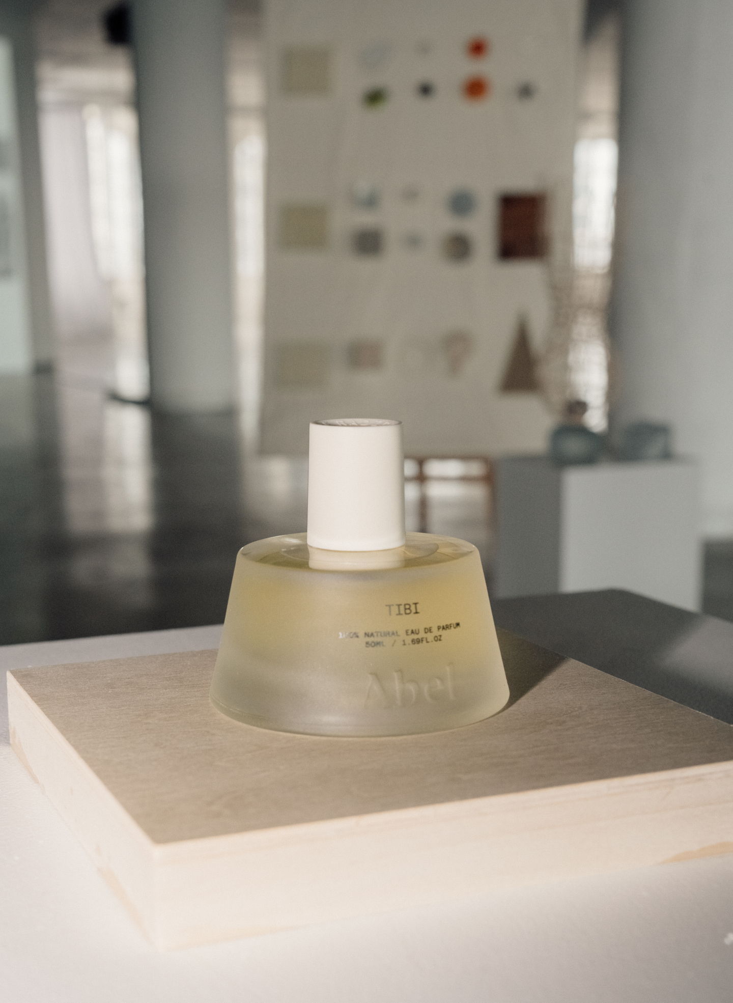 A perfume bottle on a display in a gallery setting.