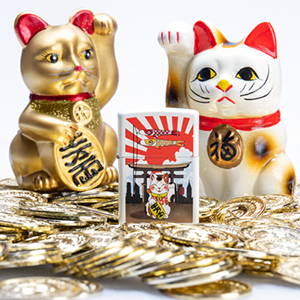 Lucky Cat design lighter, with coins in the foreground amd two lucky cat statues in the background