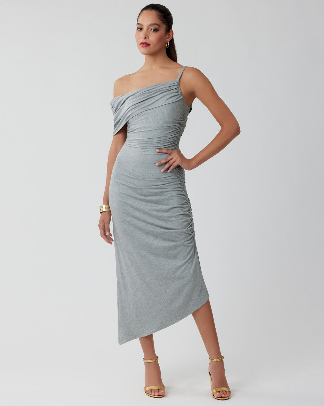 Model in a grey off-shoulder dress posing confidently.