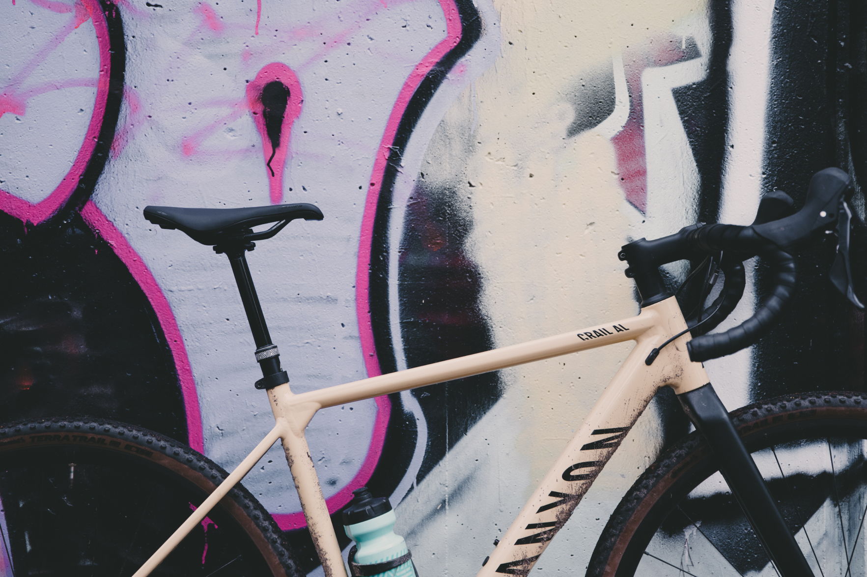 Bicycle leaning against a colorful graffiti wall.