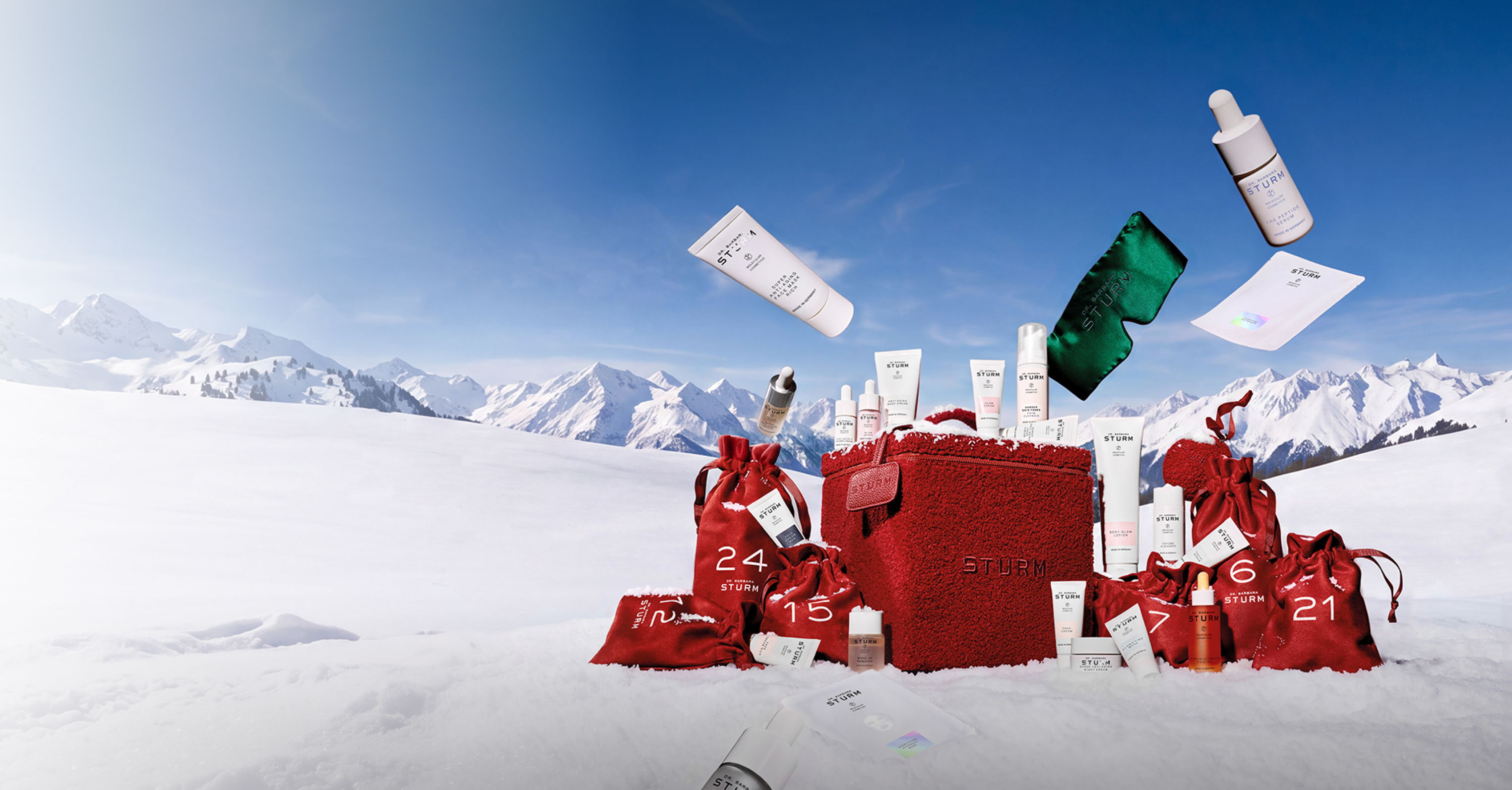 Red gift boxes and products in a snowy mountain landscape.