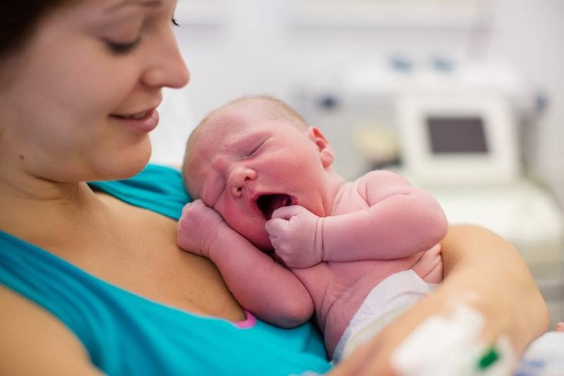 mother holding new born baby after natural birth