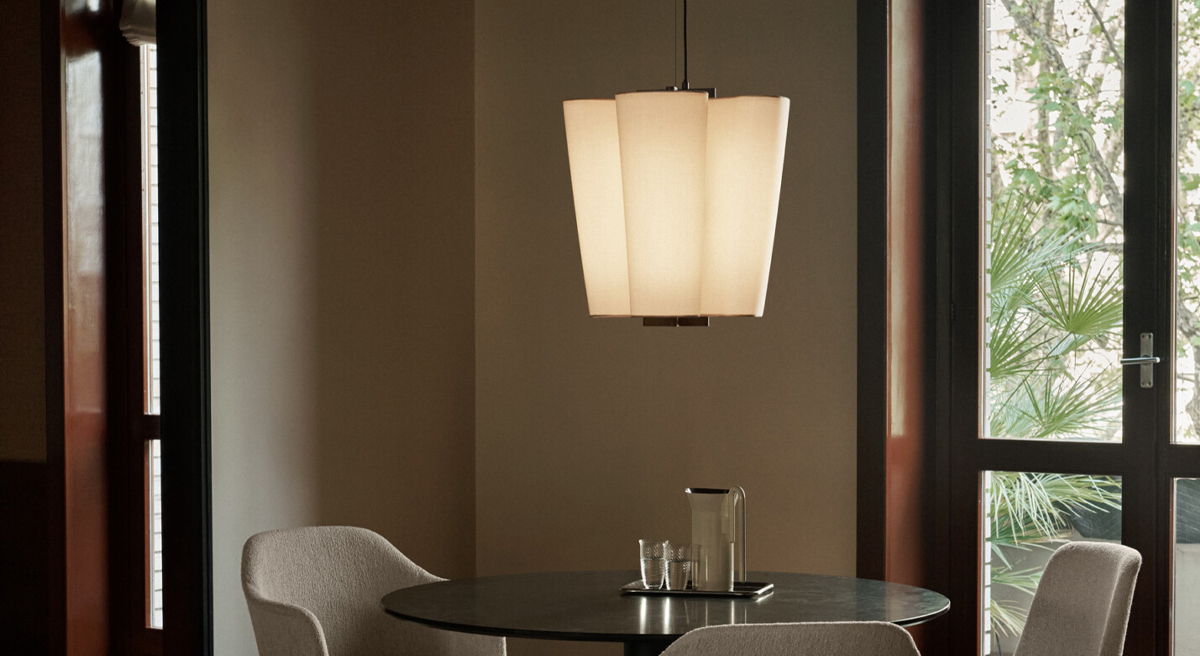 A modern dining area with a pendant lamp and a round table.