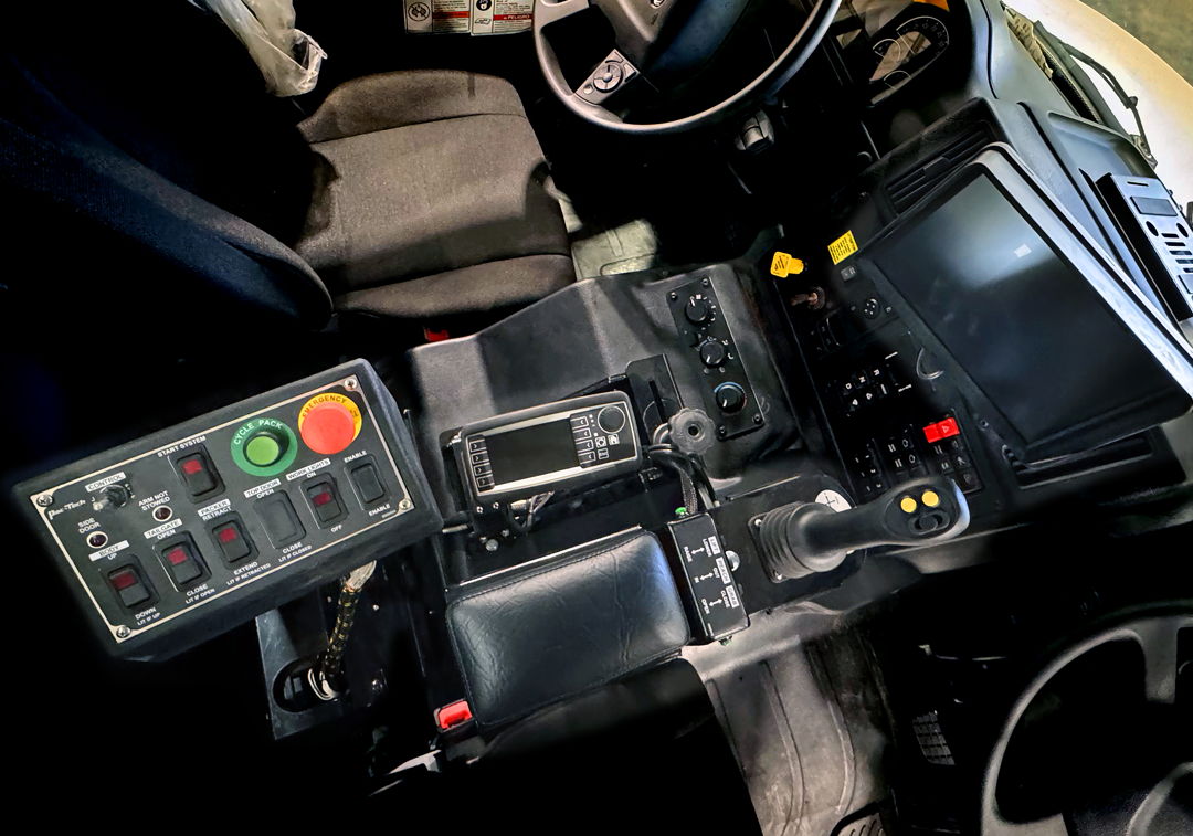 Close-up of a vehicle's control panel with various buttons and screens.