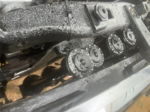 Close-up of four black circular horns mounted in row behind front bumper covered in water droplets