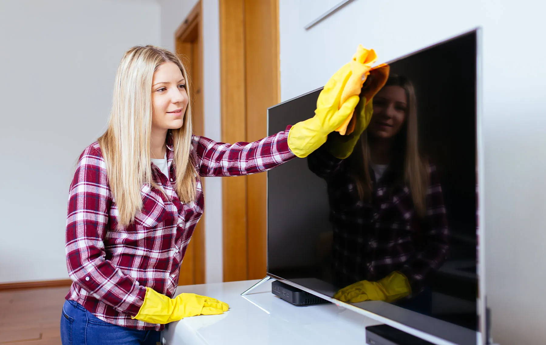 žena čisťí televíznu obrazovku