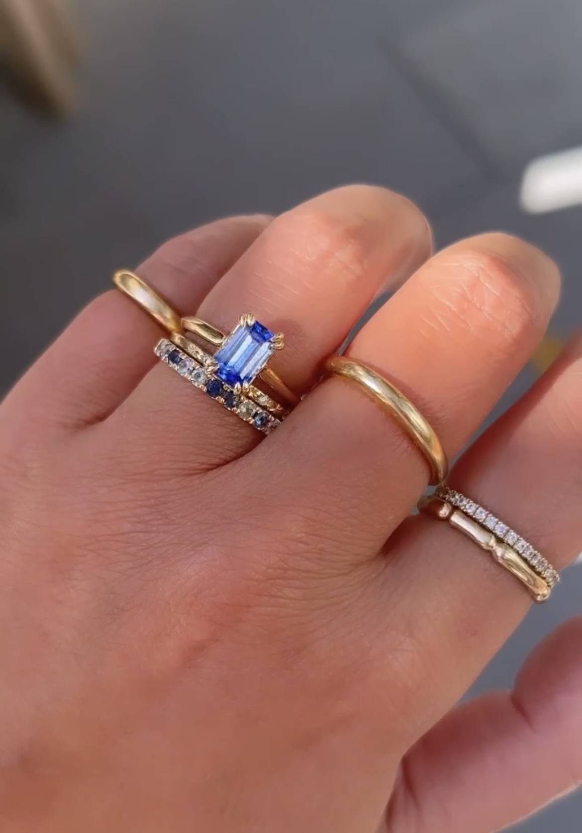engagement ring stack with sapphire ring and gold wedding bands