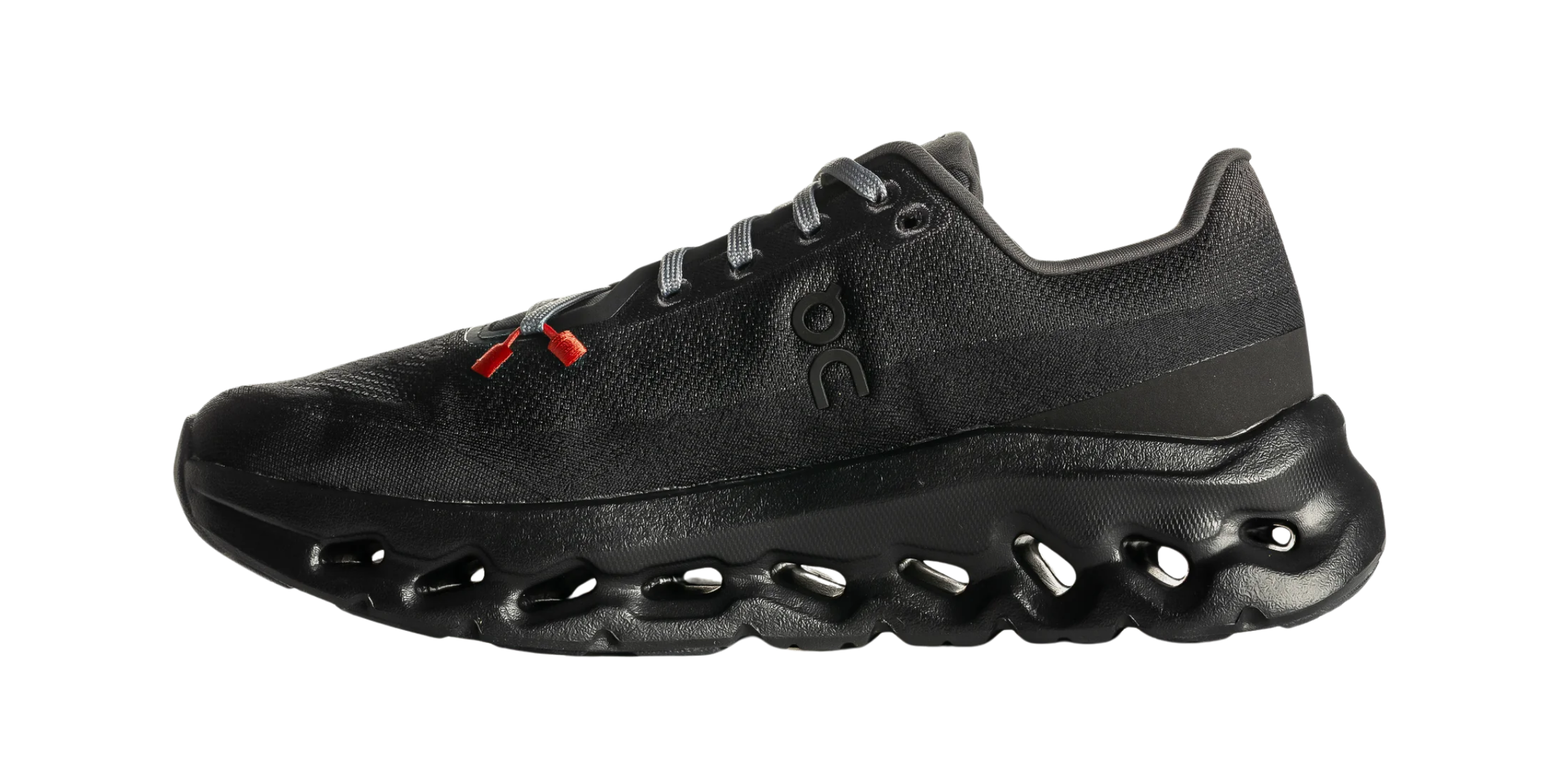 Black athletic shoe with red accents and unique sole design.