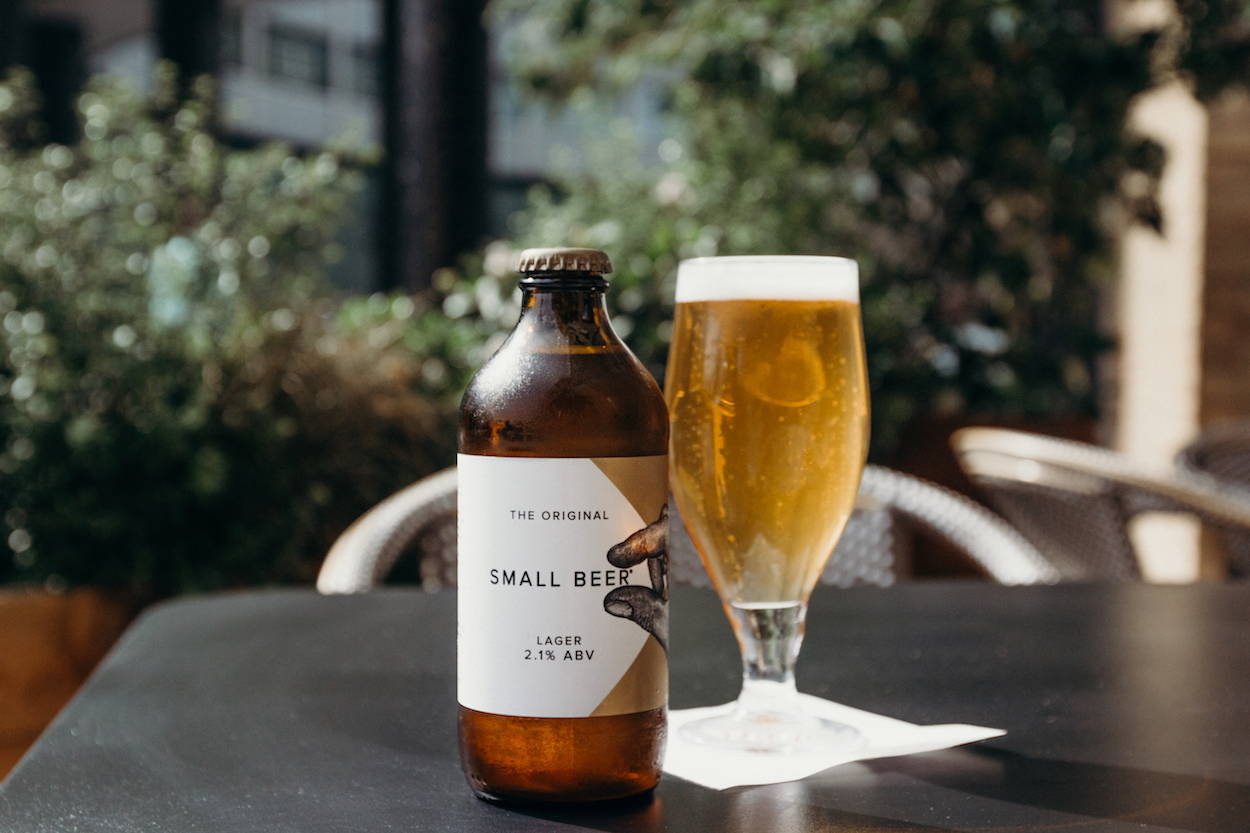 A glass of Small Beer Lager placed on a table