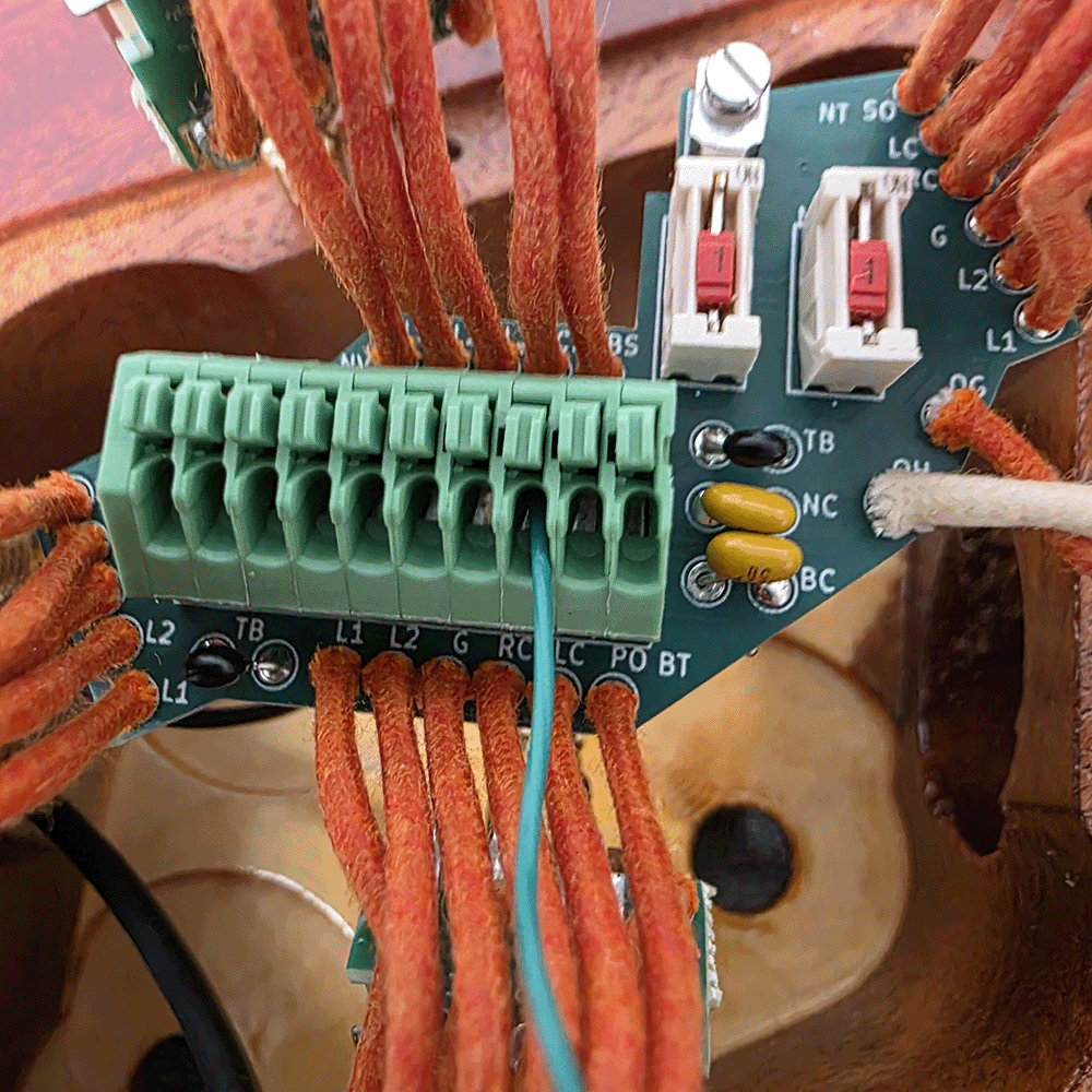 Green circuit board with wires and connectors.