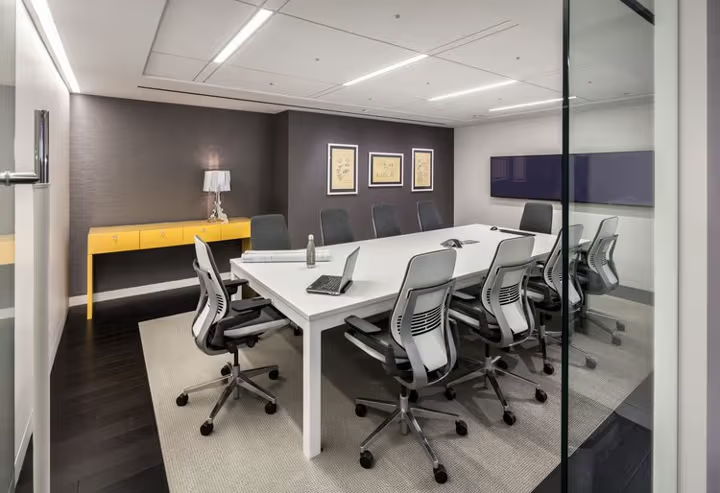 Modern conference room with a large table and ergonomic chairs.