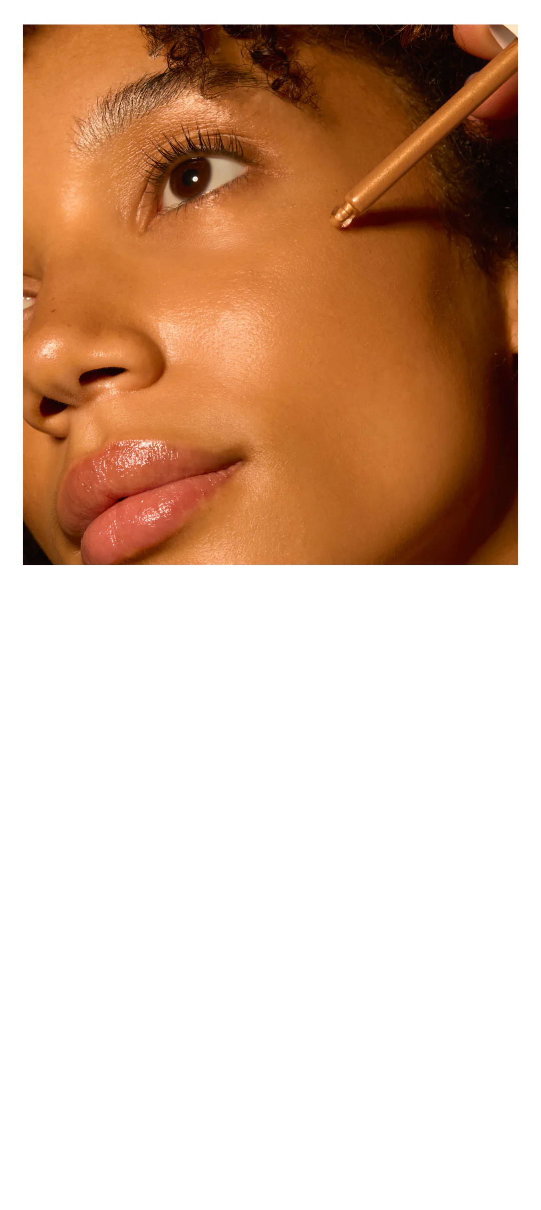 Close-up of a person applying makeup on their cheek.