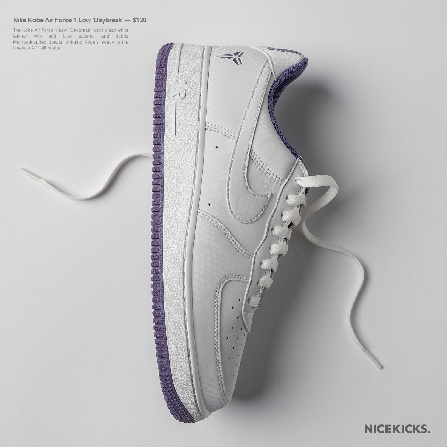White Nike Air Force 1 sneaker with purple accents on a gray background.