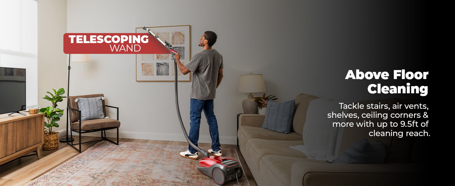 Person using a vacuum cleaner for above-floor cleaning in a living room.