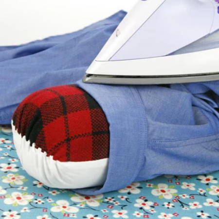 Ironing a sleeve on a sleeve roll with a hot iron