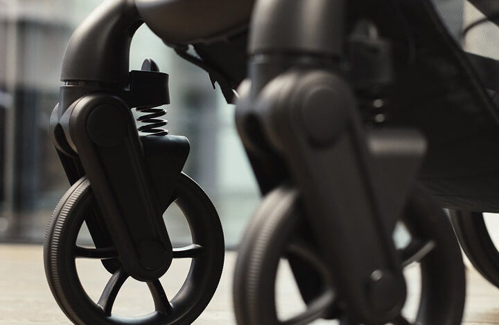 Close-up of iCandy Peach 8 stroller wheels with suspension on a smooth surface.