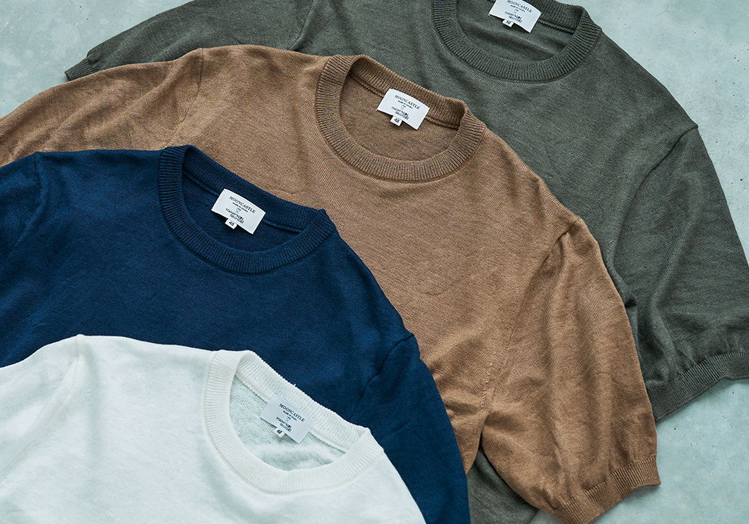 Four assorted colored t-shirts laid flat on a surface.