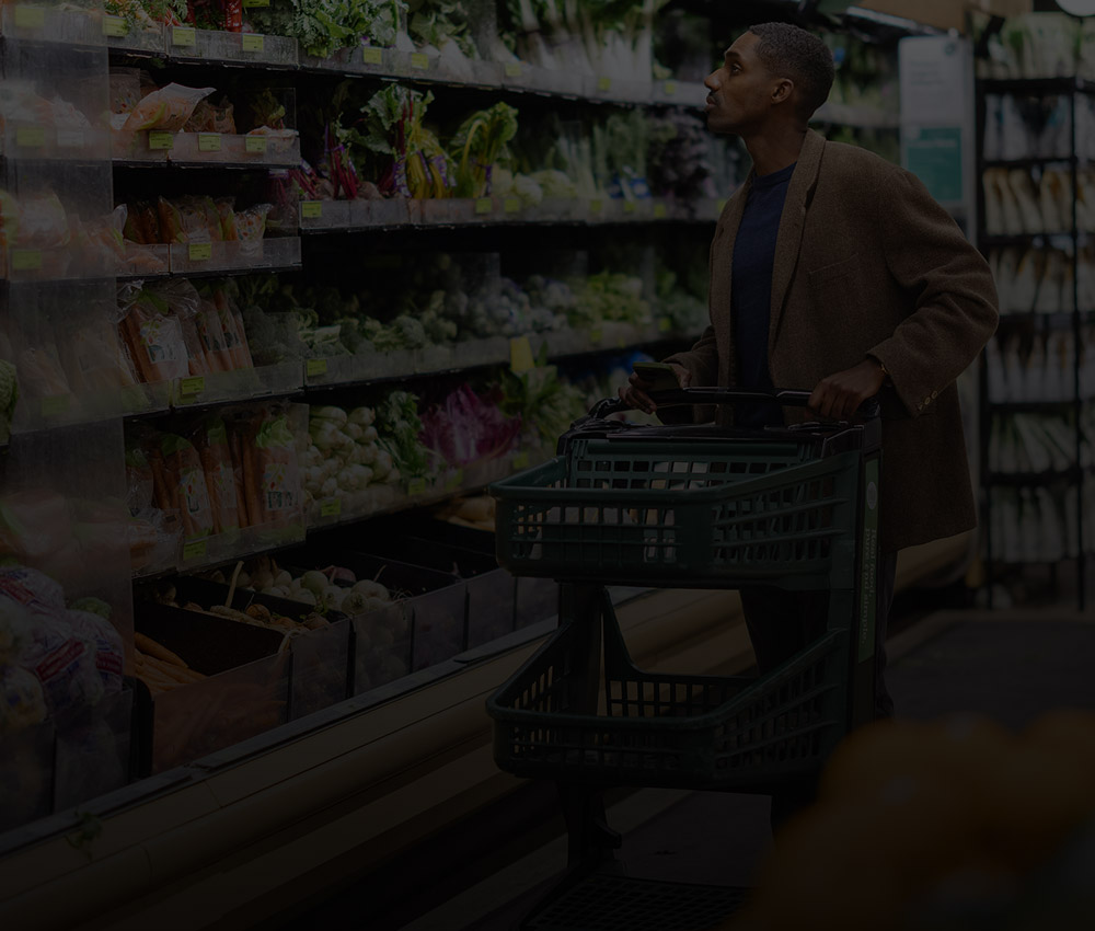 Customer shopping in a grocery store aisle, representing security and monitoring solutions for retail businesses