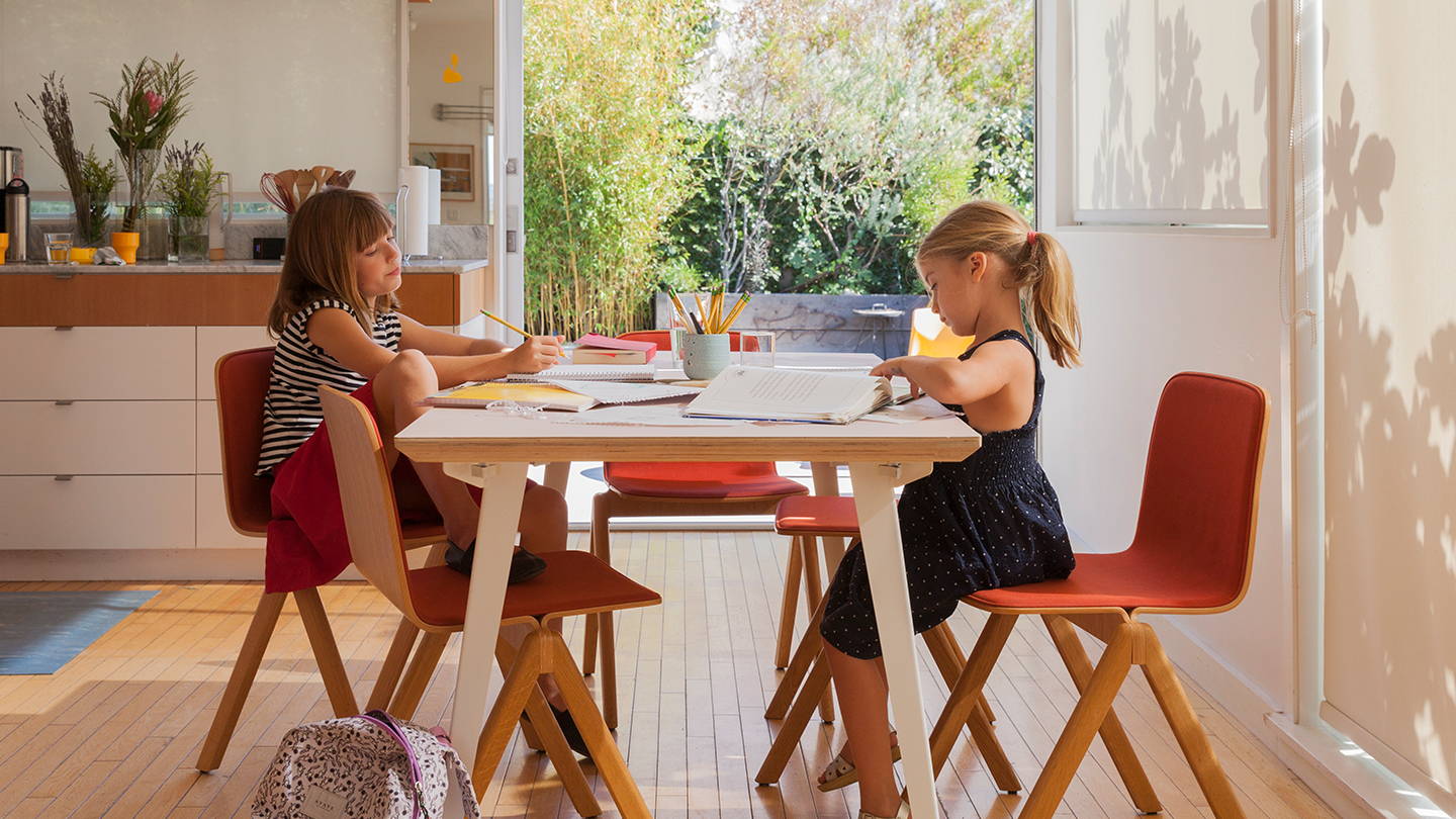 Two children doing homework at a Floyd dining table