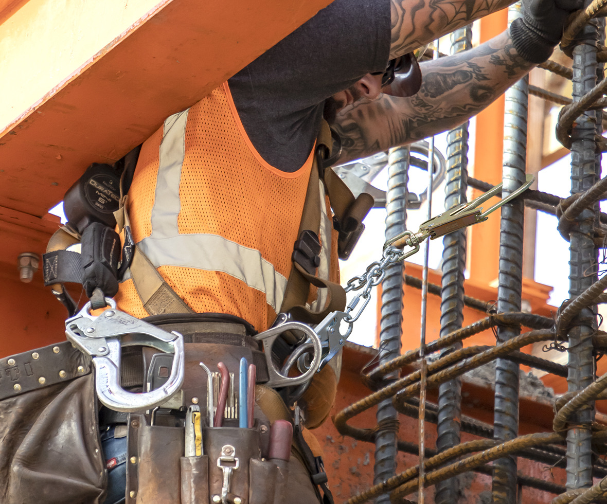 Construction worker attached to rebar using a work positioning connector