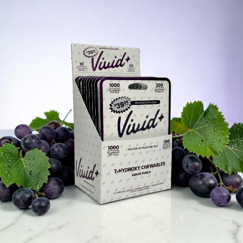 Box of Vivid dietary supplements surrounded by grapes and green leaves.